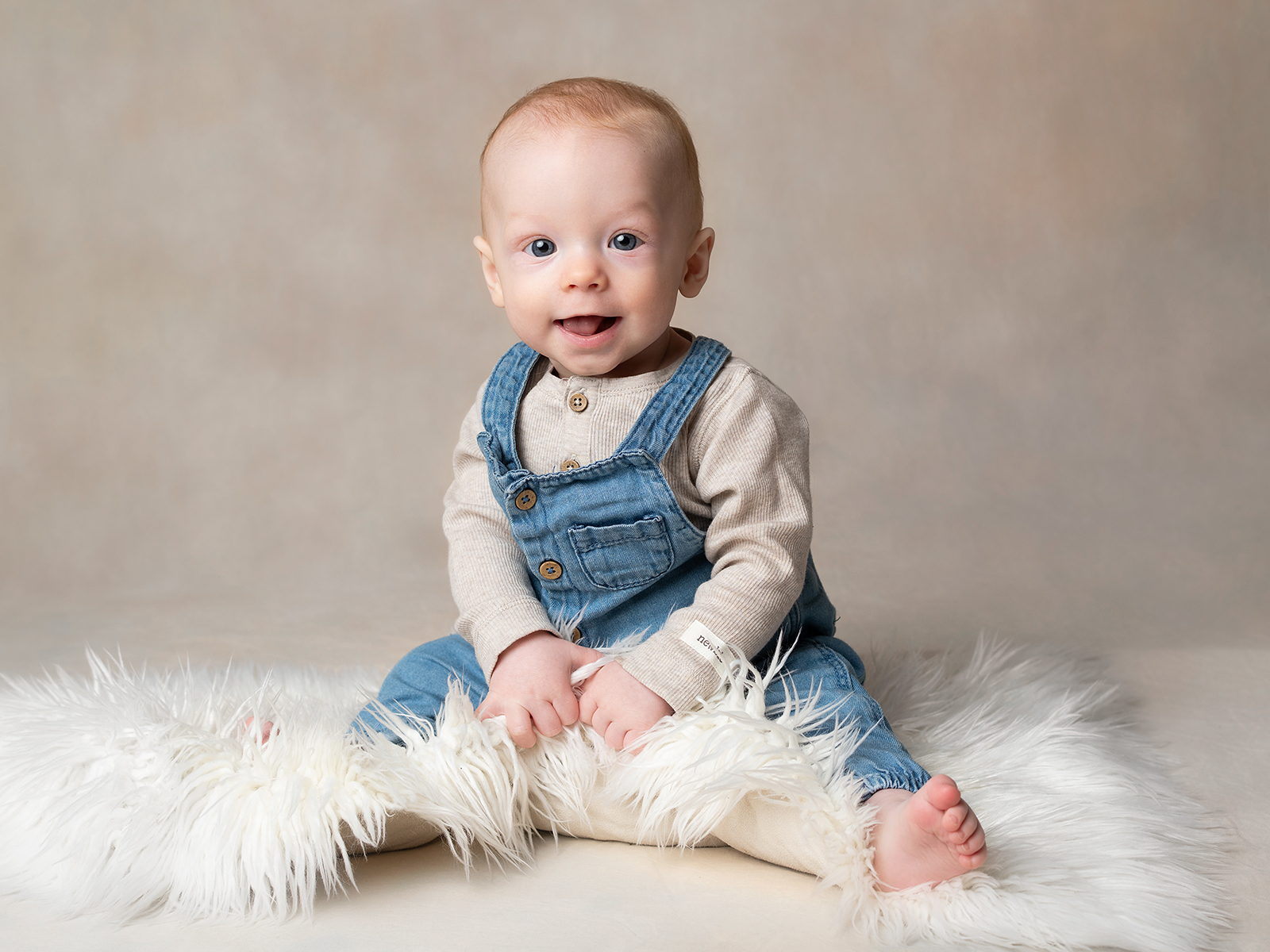 bebisfoto med 7 månaders bebis som sitter på fäll